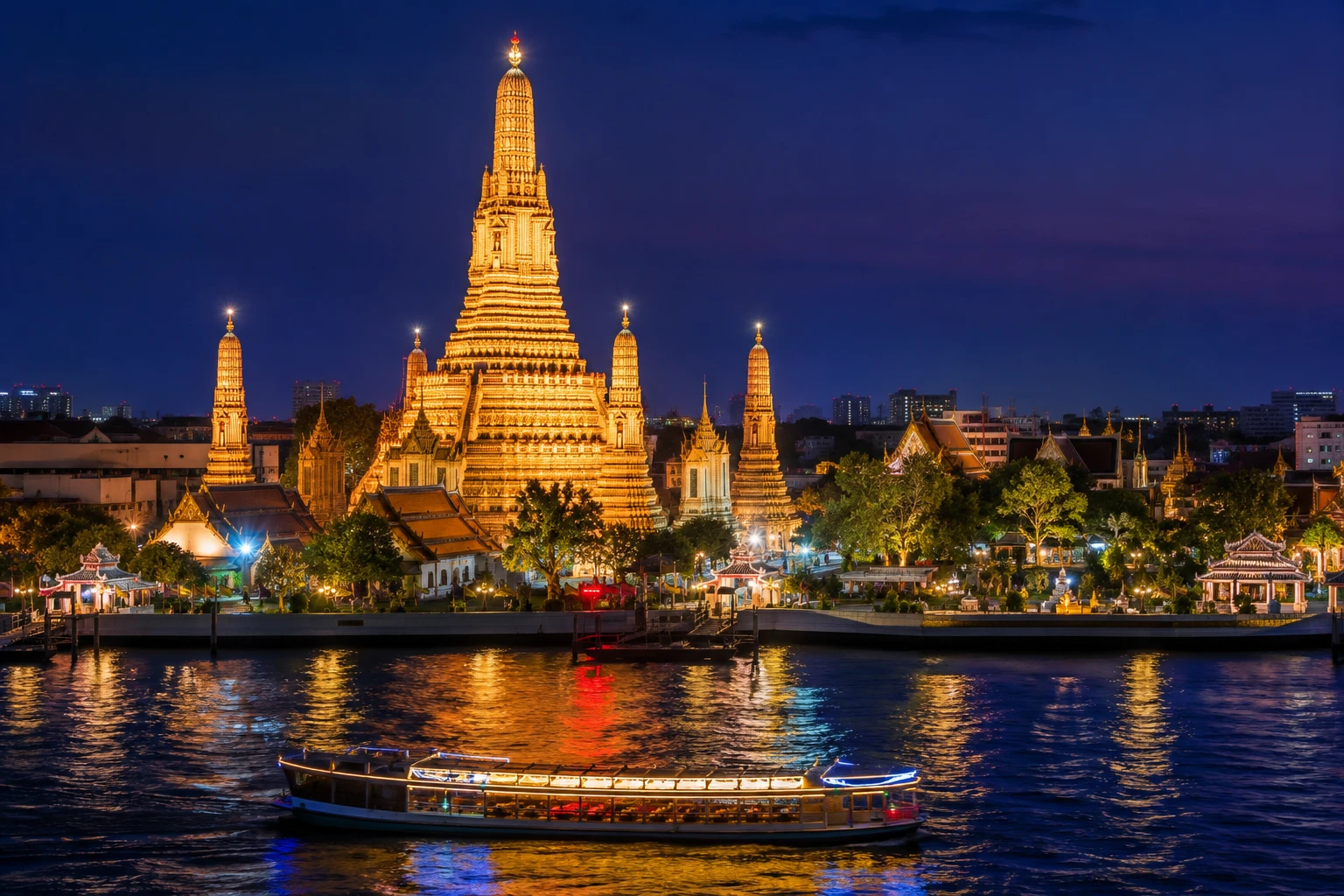 Wat Arun illuminated above the Chao Phraya River at dusk, Bangkok, Thailand
